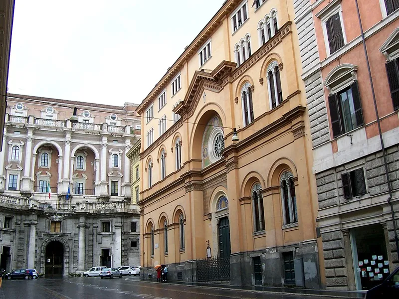 The Waldensian church on Via Quattro Novembre in Rome seen from the street, an ochre building with arched windows and a cross over a mosaic arch.
